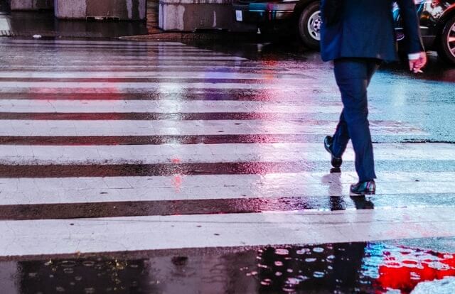 雨の中スーツ姿で歩く男性